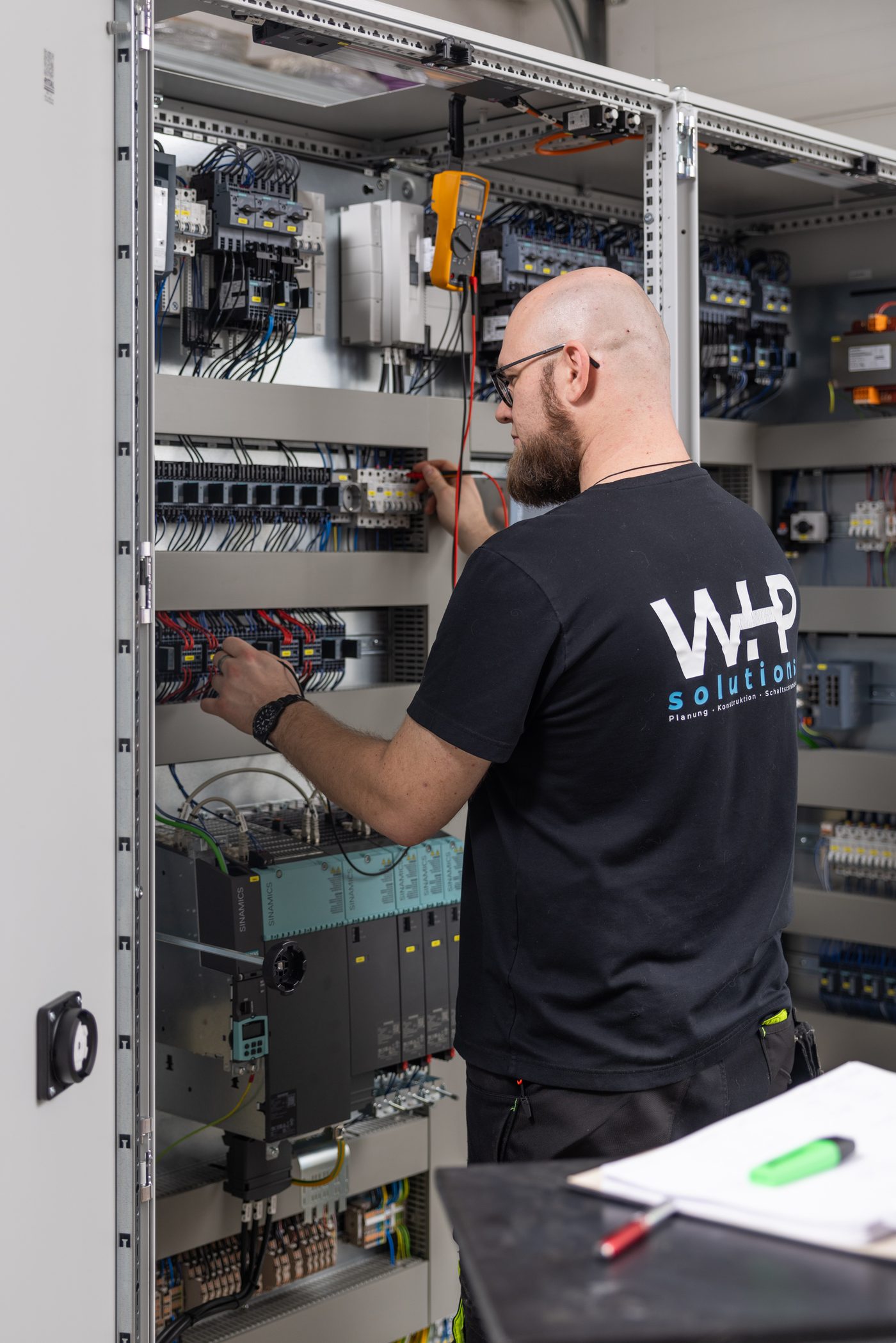 A man checking the connections in a control panel